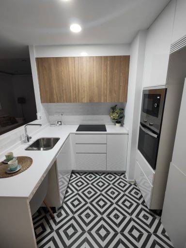 Cocina moderna con muebles blancos, encimera negra y suelo en mosaico geométrico.